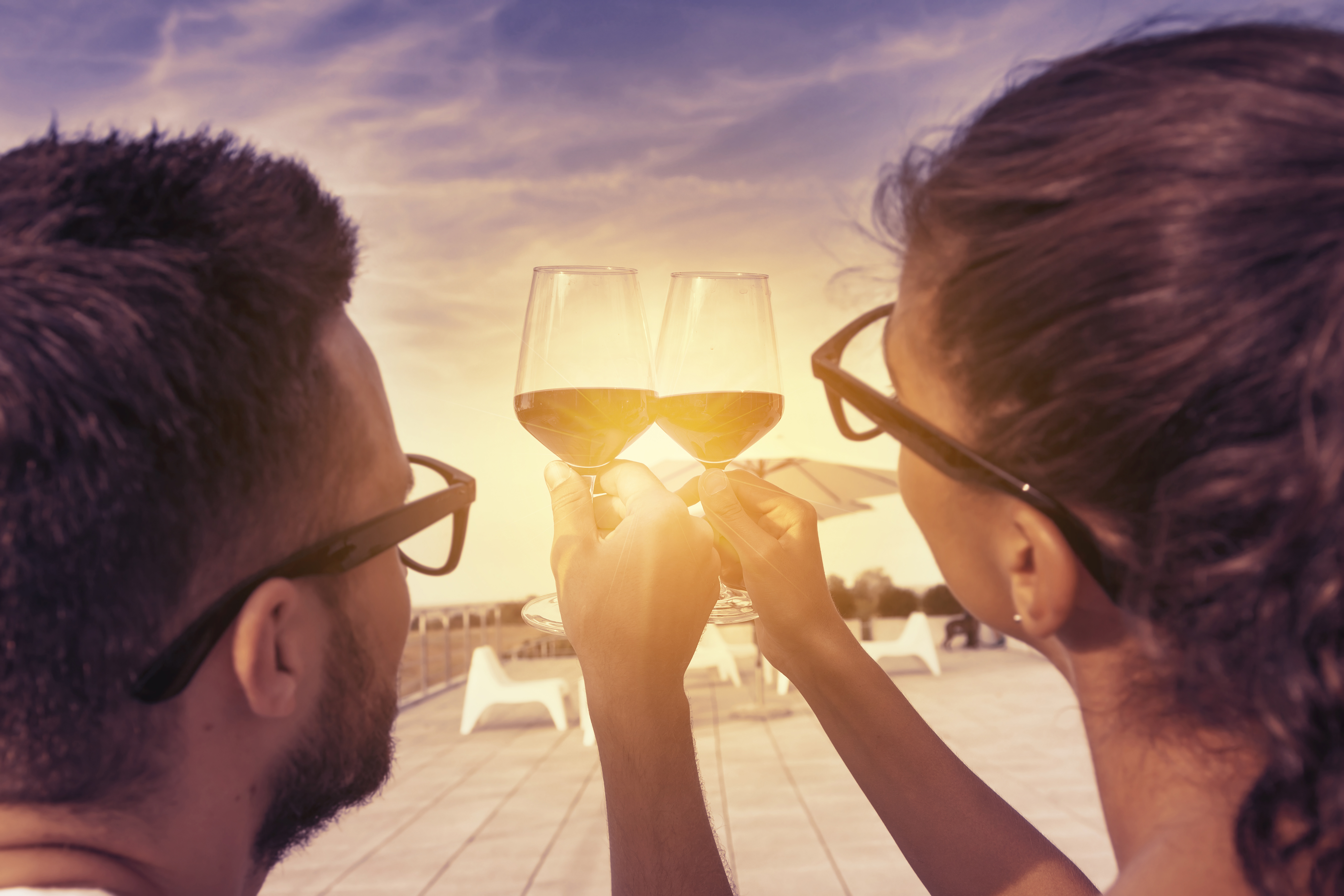 vecteezy_young-couple-toast-on-a-terrace-at-sunset_53607192.jpeg
